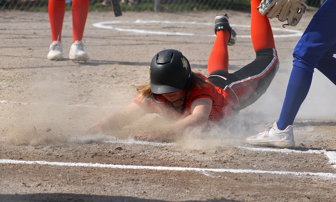 A Ronan runner goes headfirst on a slide to get the score in a battle against Libby. (Kaleb Unger/Leader)