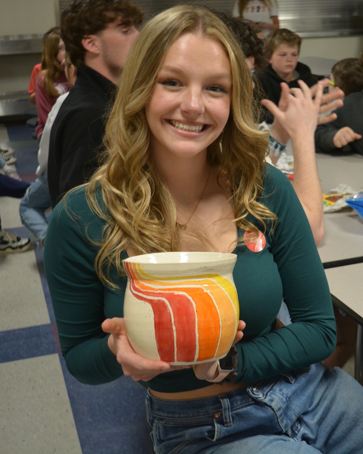 Emmery Fuller shows off the colorful ceramic piece she made at Skyway Elementary School. Students from Lake City High School shared their completed work Tuesday to elementary students whose words helped inspire the designs.