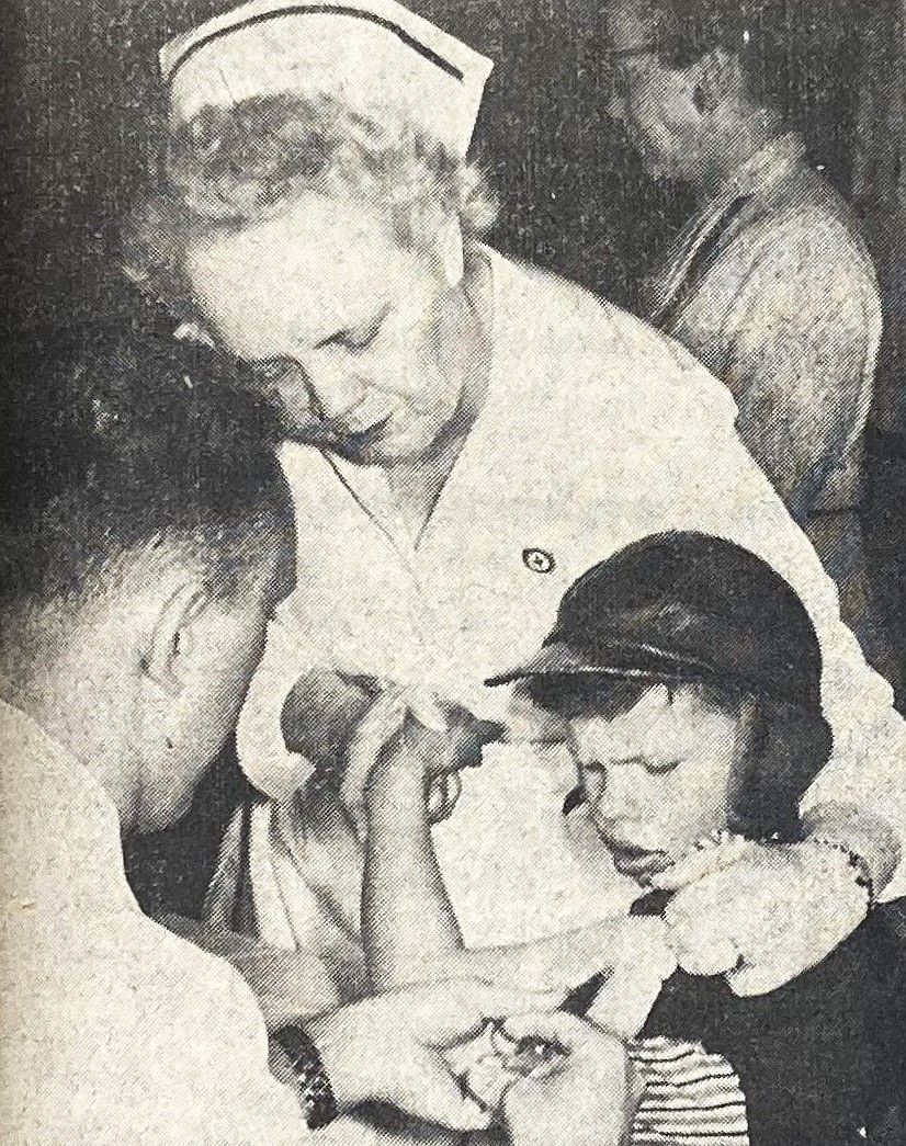 Lester Bender, 8, son of Deputy and Mrs. John Bender, is held by Mrs. Norman Spellman while Dr. W.W. Wilson administers a polio shot April 18, 1955.