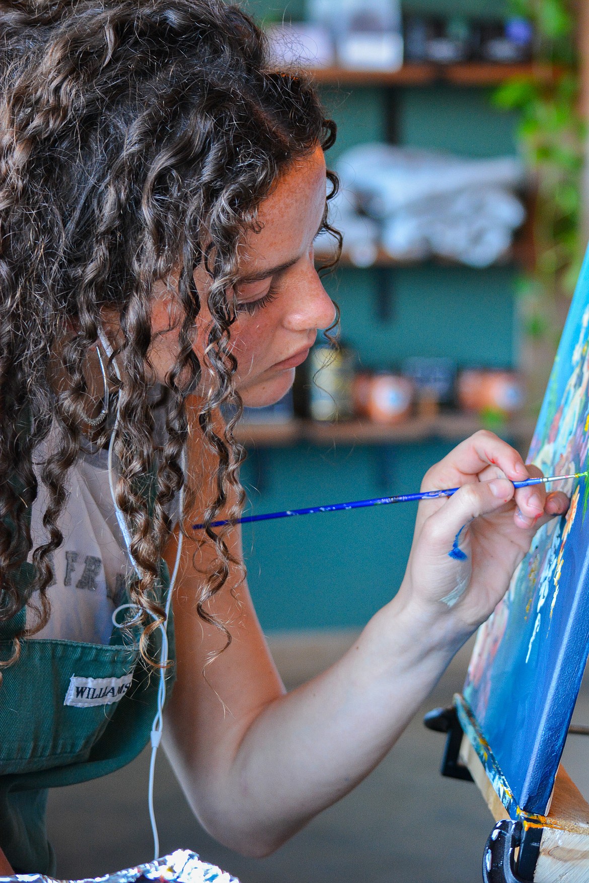 Artist Isabella Henkle is hard at work during a recent painting session. The 21-year-old local is this year's Art on the Green poster artist.