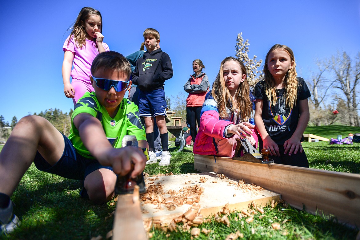 Edgerton Elementary third-graders use planers at the Flathead High School wood shop station at the Arbor Day celebration at Lawrence Park on Friday, April 25. (Casey Kreider/Daily Inter Lake)