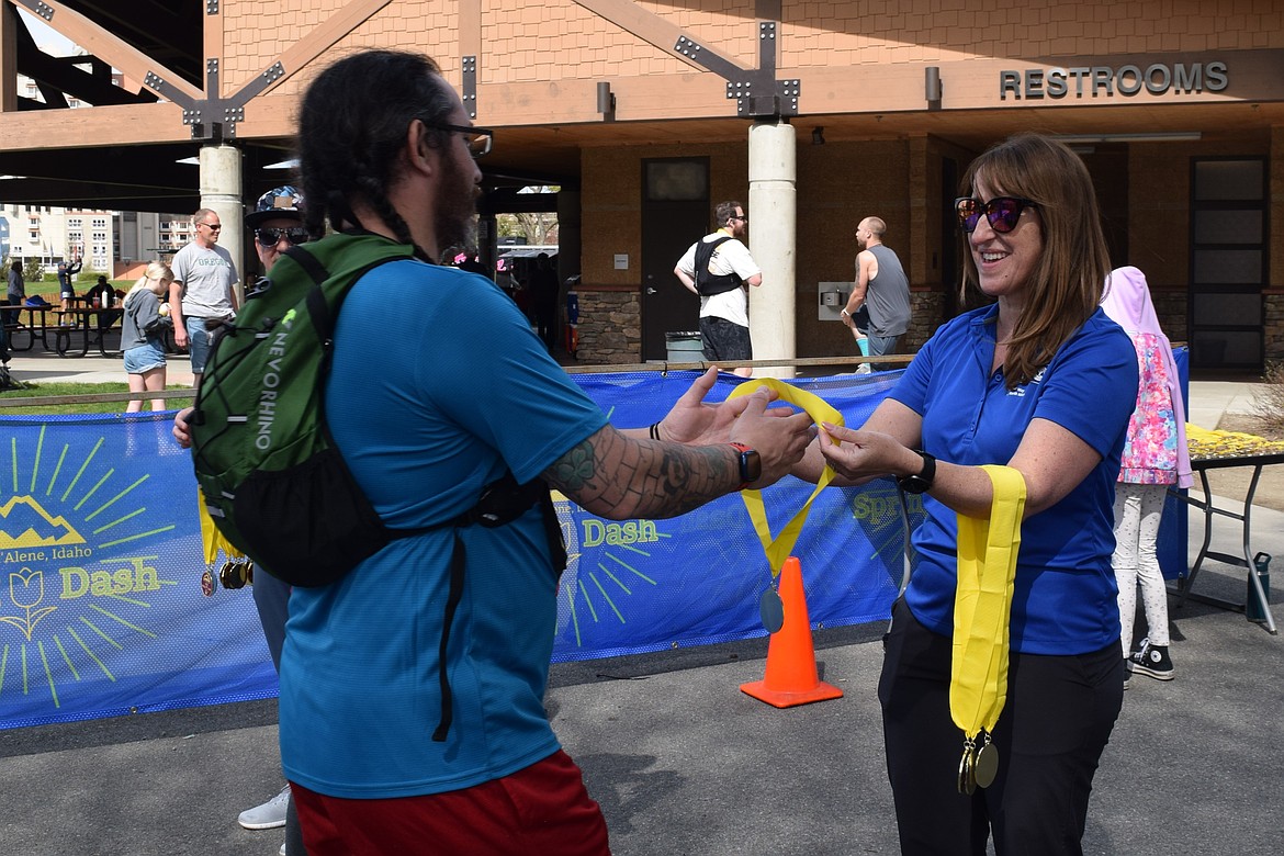Johanna Brown with United Way North Idaho hands out medals to Spring Dash racers.