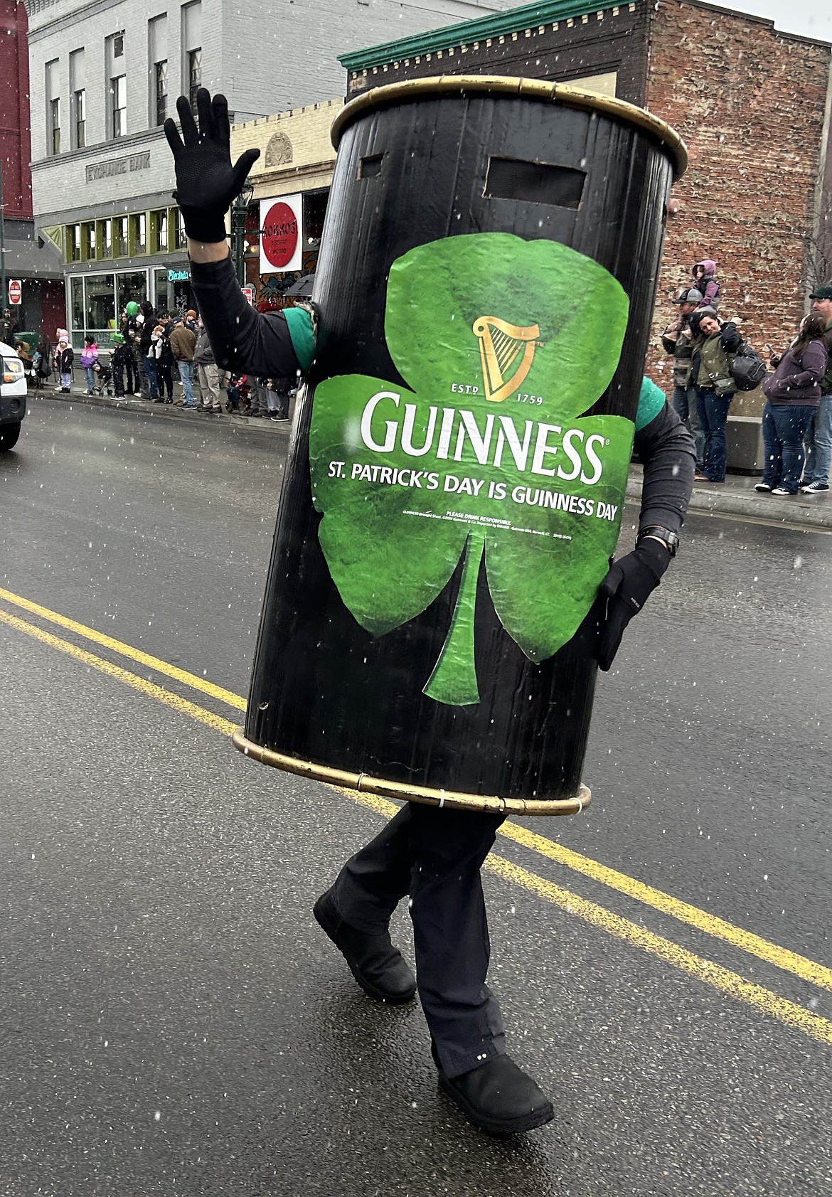 A man wearing a Guinness beer can costume joins the parade.