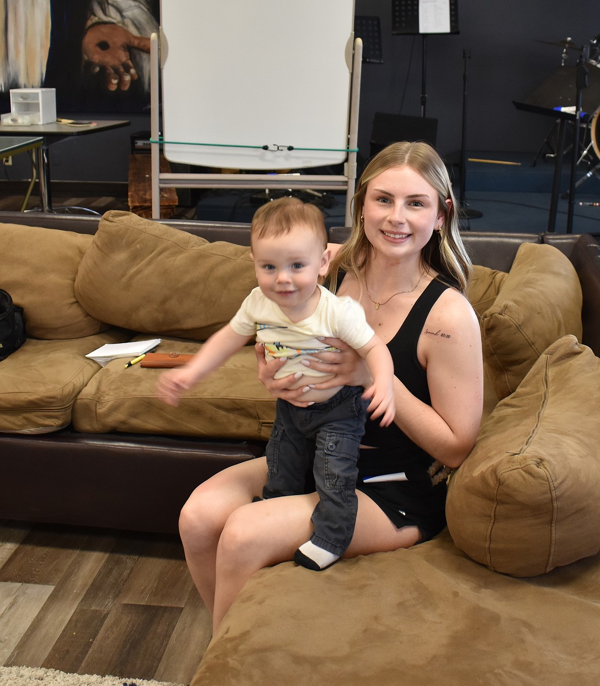Piper Bradshaw and her son Porter take a break at the YoungLives meeting Thursday at Moses Lake Alliance Church. The tattoo Bradshaw wears refers to a Bible verse that says in part “Do not fear, for I am with you.”