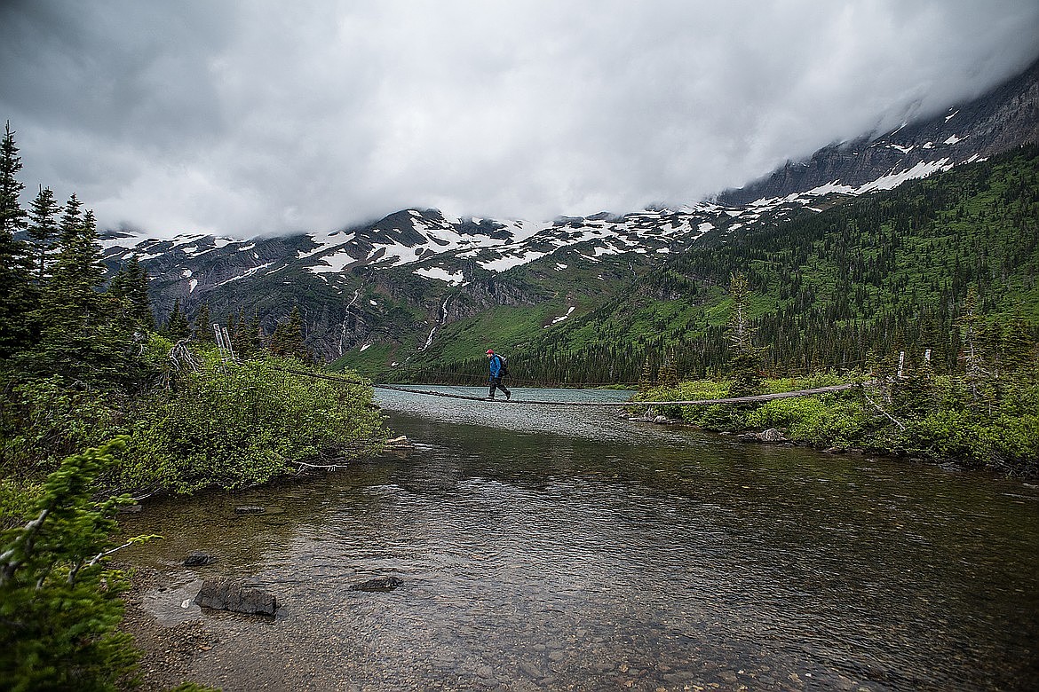 A hiker crosses the suspension bridge at Gunsight Lake. / HUNGRY HORSE NEWS