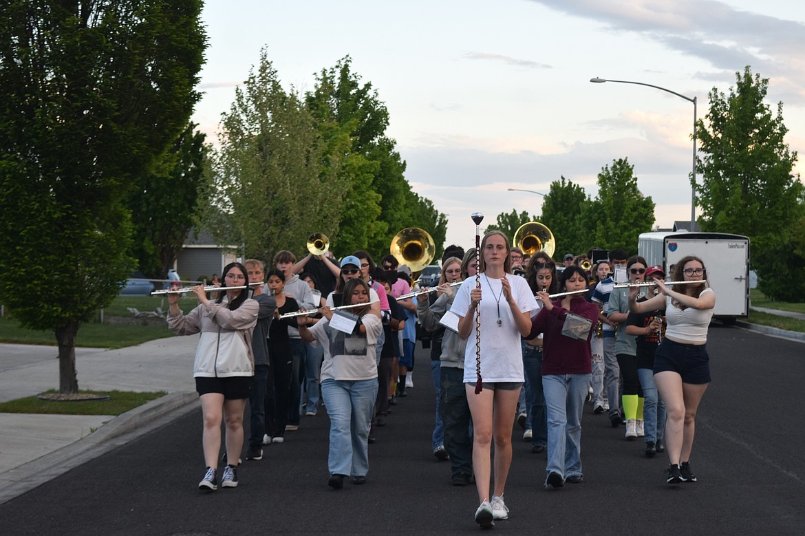 Moses Lake High School Marching Band teacher Pablo Hernandez leads students down Leanne Avenue, perfecting the students march as they play.