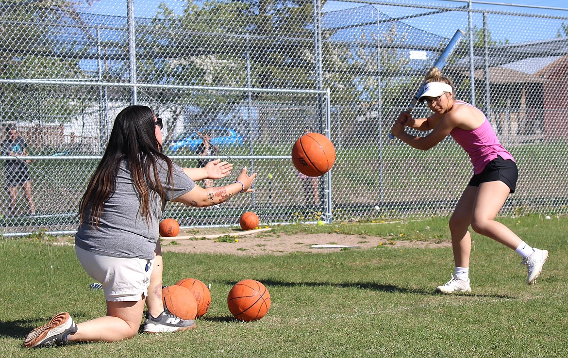 MAC assistant coach Janeal McDonald throwing soft toss to Madisyn Hanken at practice. (Kaleb Unger/Leader)