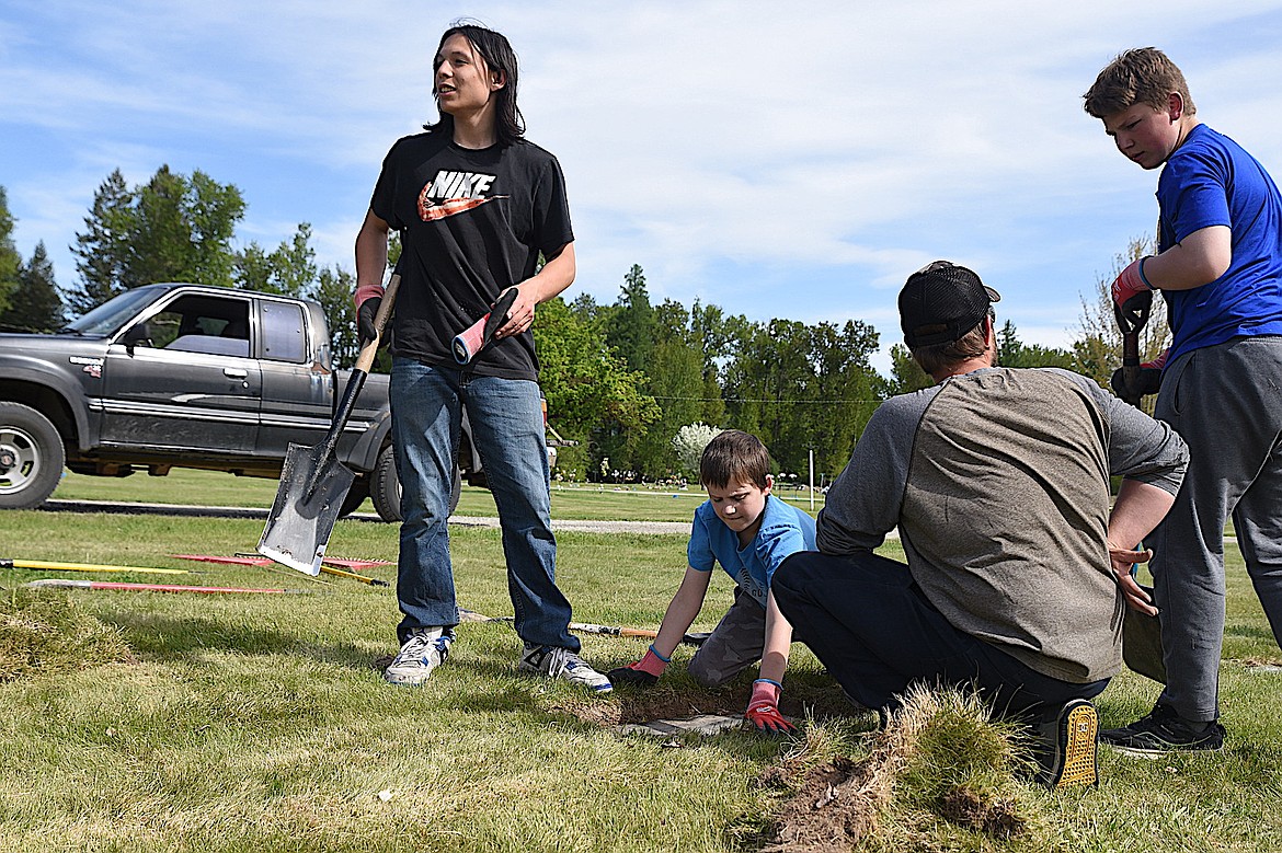 Eagle Scout candidate Dominic Thom, left, and Libby Boy Scout Troop 1971 members work at a grave site in the City of Libby Cemetary Friday, May 9, 2025. Thom's Eagle Scout project was to refurbish headstones that had sunk lower than ground level over the years. (Scott Shindledecker/The Western News)