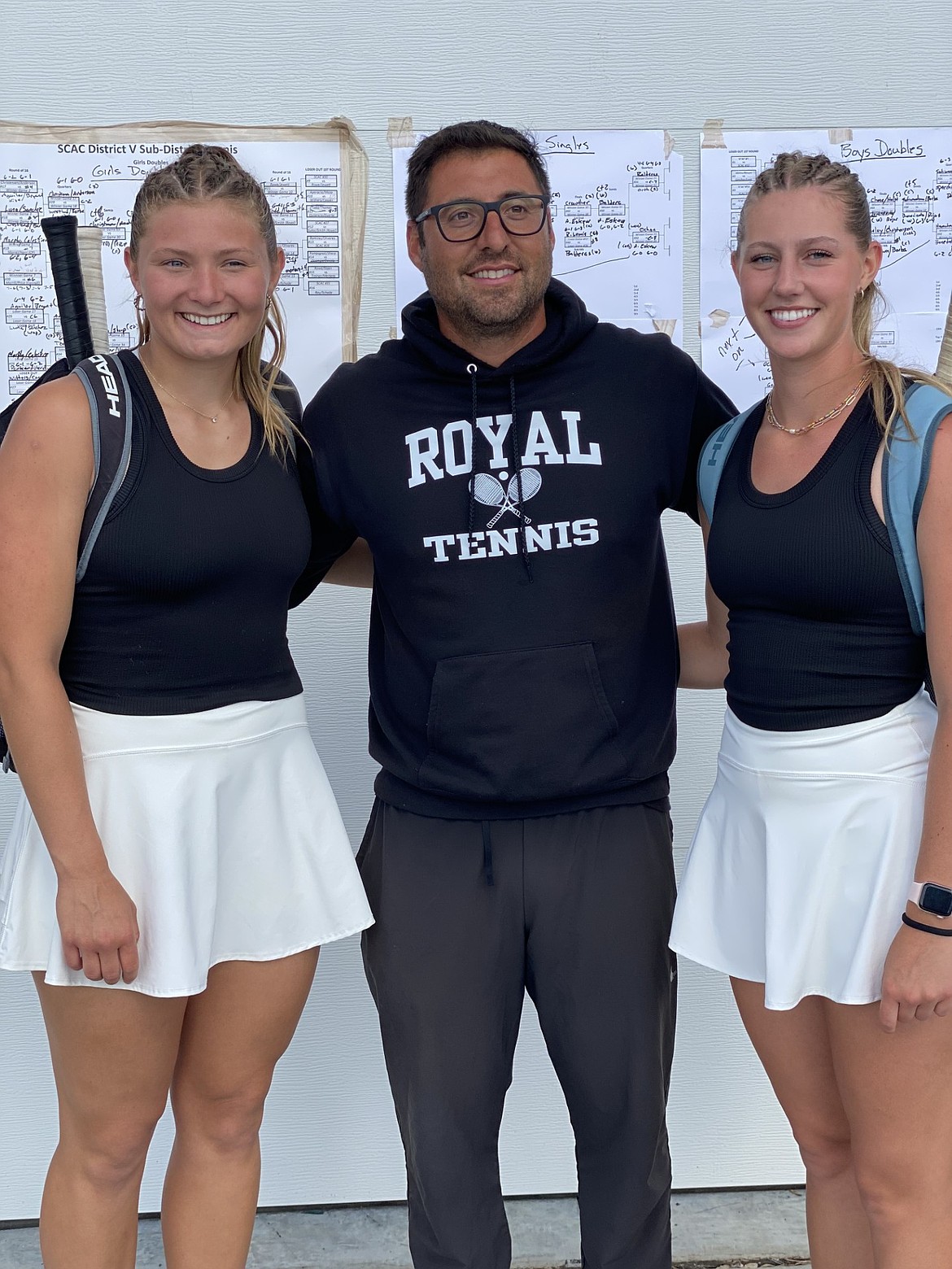 Knights coach Rodrigo Fajardo stands with Madi Christensen, left, and Campbelle Anderson, right, after the two become SCAC subdistrict champs in girls' doubles.