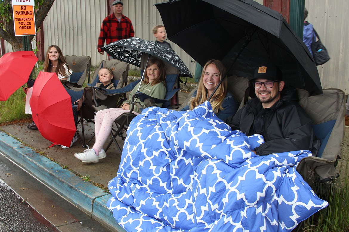 Annette Borges and Nathan Shapiro stay warm under a thick blanket and dry under a big umbrella as they wait for the start of the classic car cruise as Lost in the '50s fun kicked off on Friday.