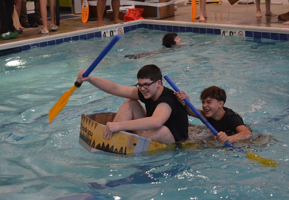 Two students prepare to abandon ship as their cardboard boat ceased to float at the SafeSplash pool.