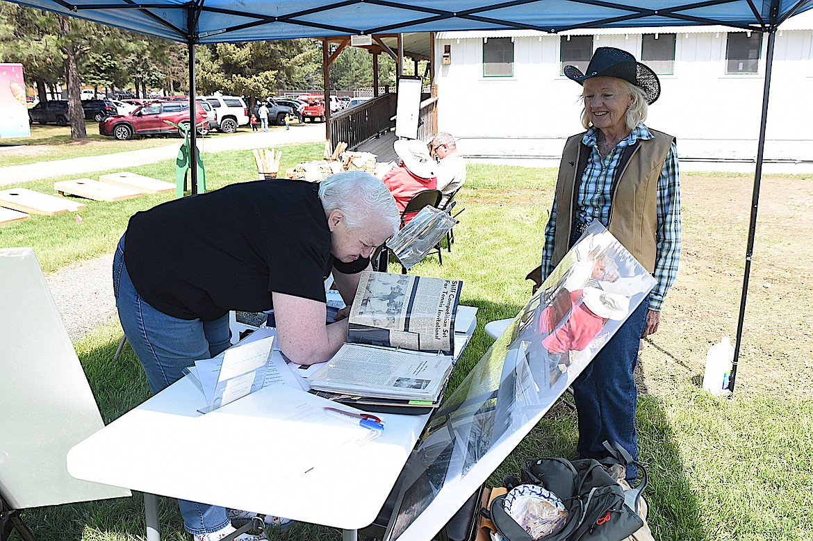 Libby resident Doreen Tiffany enjoys leafing through binders of Libby history compiled by Pat Neils, right. Neils was at the Heritage Museum during opening-day festivities Saturday, May 17, 2025. She is planning on publishing a book this year centered on the history of the Neils family in Libby. (Scott Shindledecker/The Western News)
