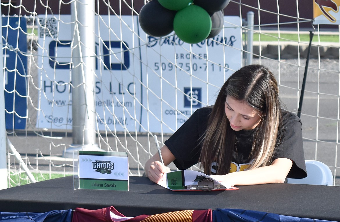 Liliana Savala signs her letter of intent to play for Green River Community College. She said she had not planned to play soccer in college but was scouted by Green River after seeing her play for the Basin Sounders soccer team.