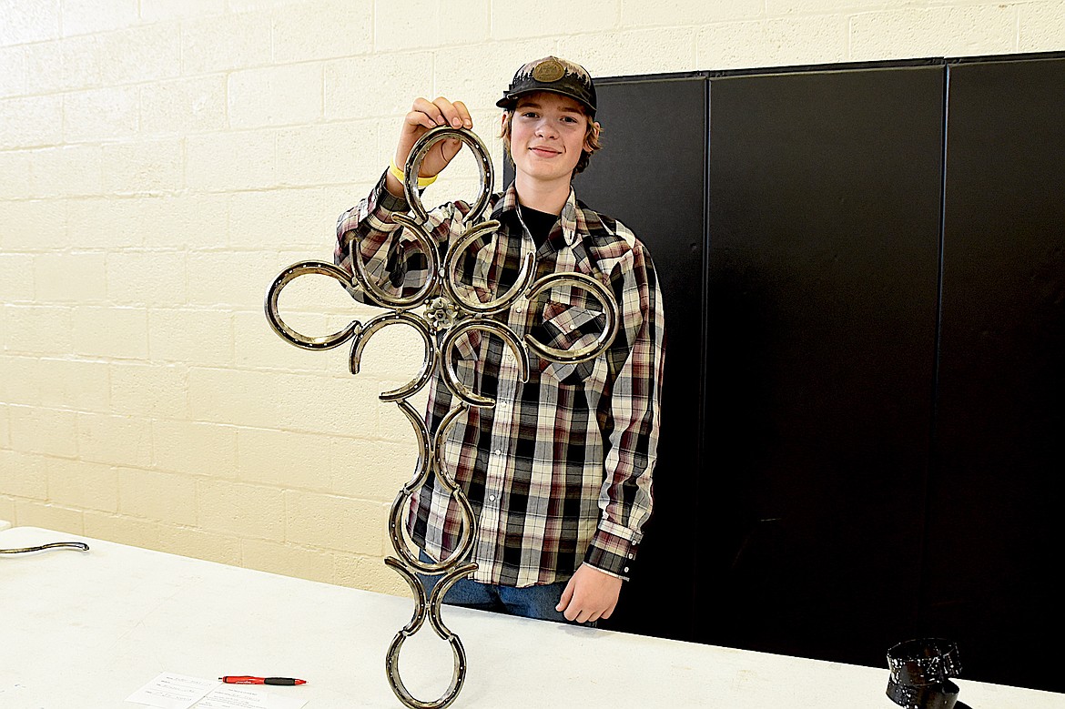 Troy High School sseventh-grade student Ruger Headrick displays his cross made of horseshoes at the school's annual student art show Tuesday, May 20, 2025. (Scott Shindledecker/The Western News)