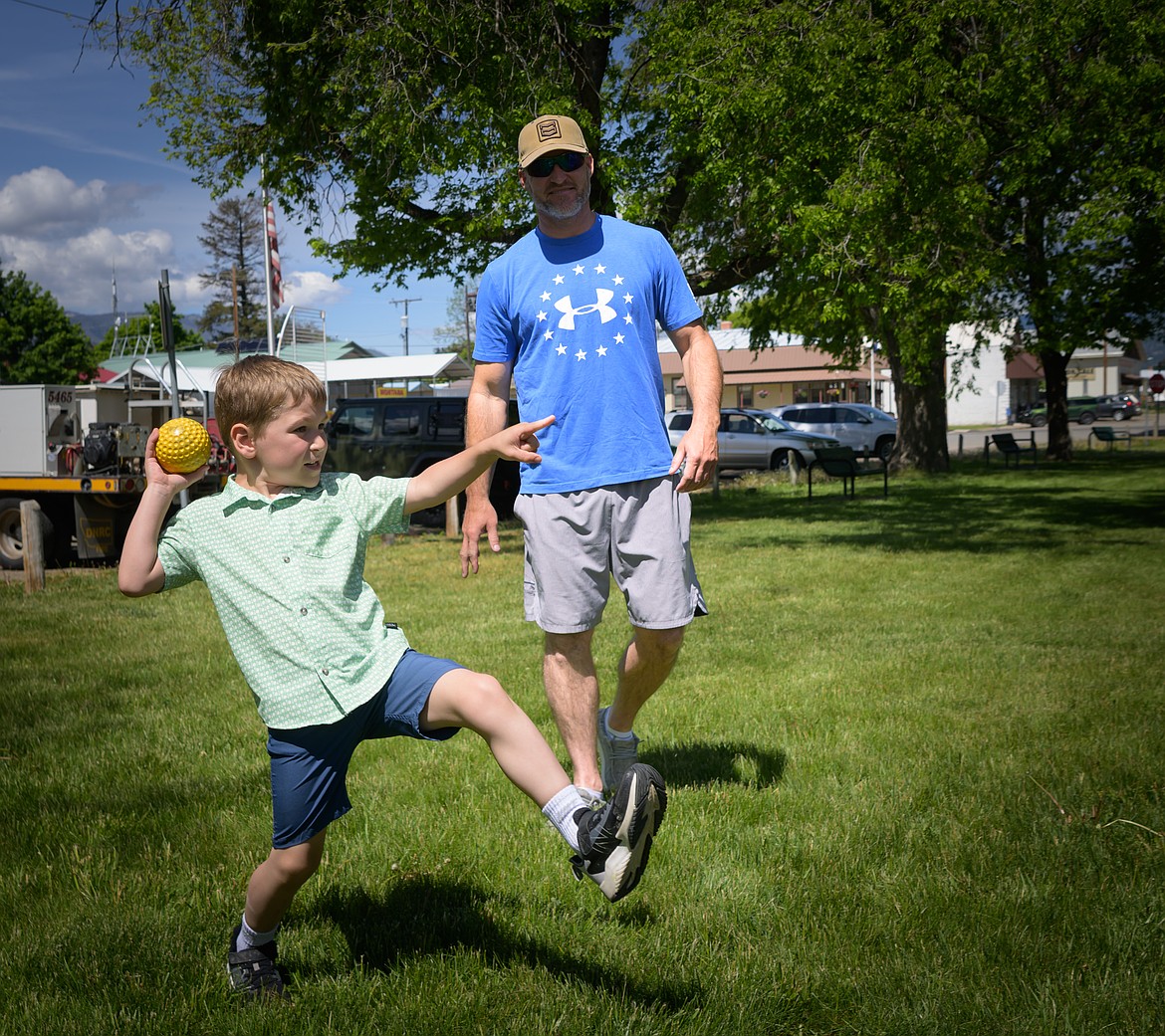 Rafe Bache, 5, winds up to dunk DNRC firefighter Andrew McCalmant with his dad Adam Bache looking on. (Tracy Scott/Valley Press)