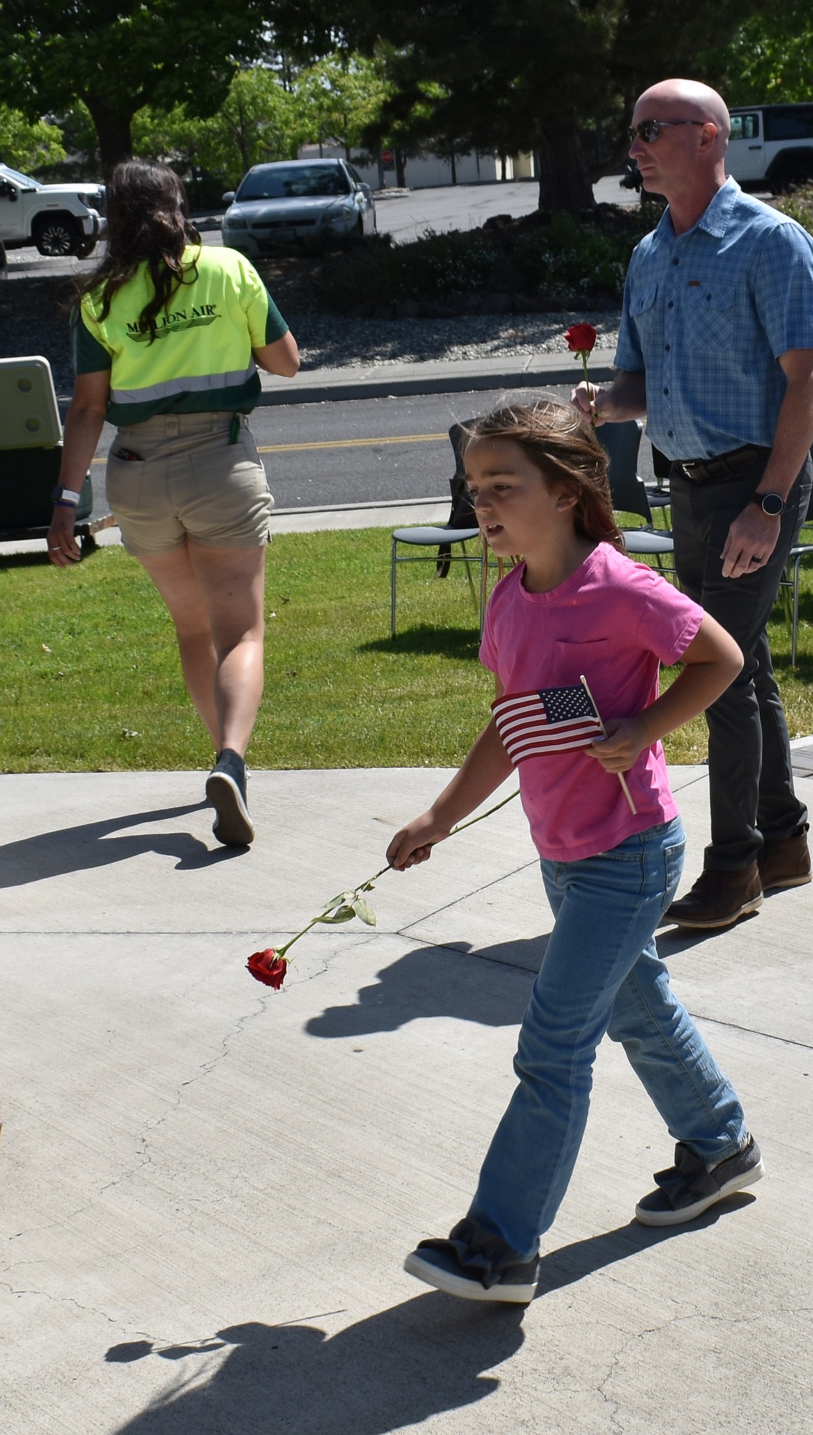 Seven-year-old Micae Wood brings a rose to lay down at the Forgotten Heroes Memorial Monday morning in Moses Lake. Micae was there with her mom, grandmother and great-grandparents to honor the 87 servicemen who died in a plane crash at Larson Air Force base in 1952.