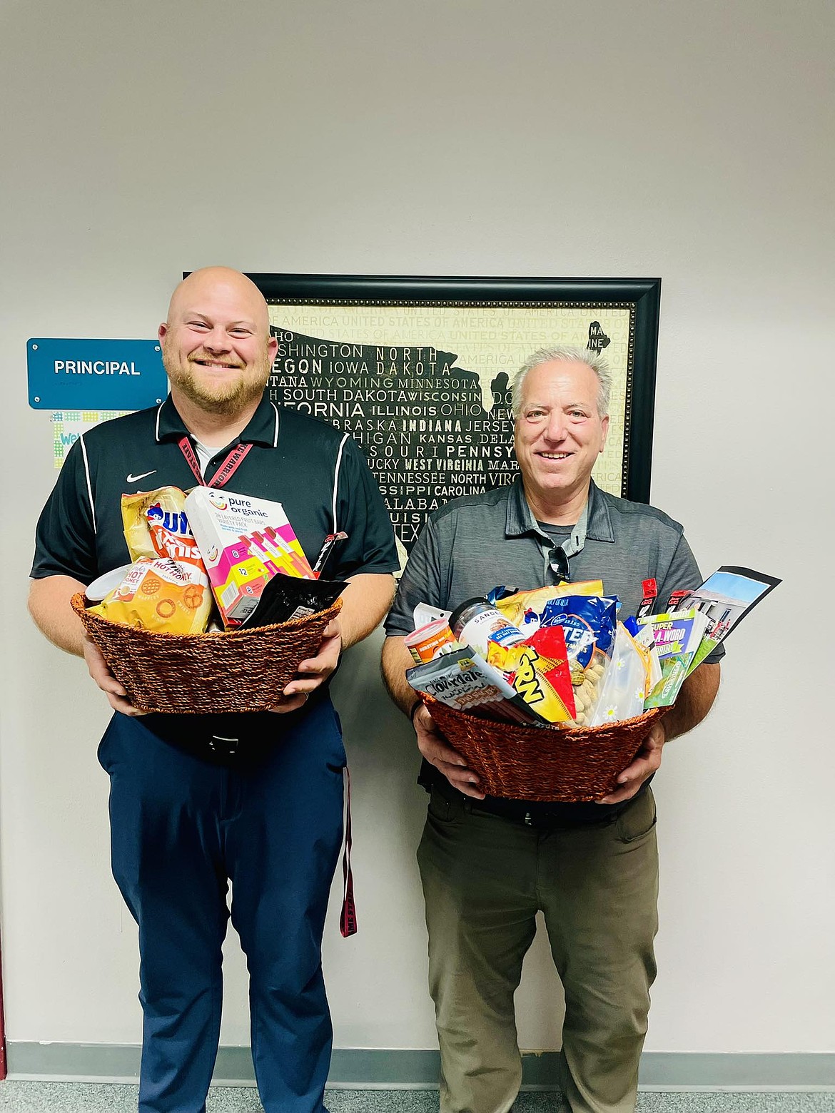 Saddle Mountain Elementary Principal Kurt Hoffman, right, and assistant principal Anthony Voelker, left, show the gifts they received for National School Principal Day. After a 40-plus year career in education, Hoffman is retiring at the end of the school year.