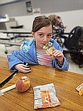 A child eats applesauce at a summer lunch program offered last summer. This year, summer lunches will be offered by school districts around the Basin for children in the area 18 and younger.