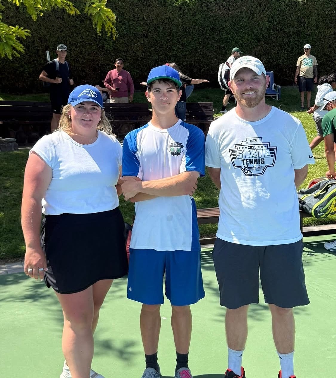 Soap Lake tennis coaches Clarissa Larsen and Lee Leavell stand with Xavier Ewing at the state tournament. Leavell said he was very proud of Ewing’s performance.
