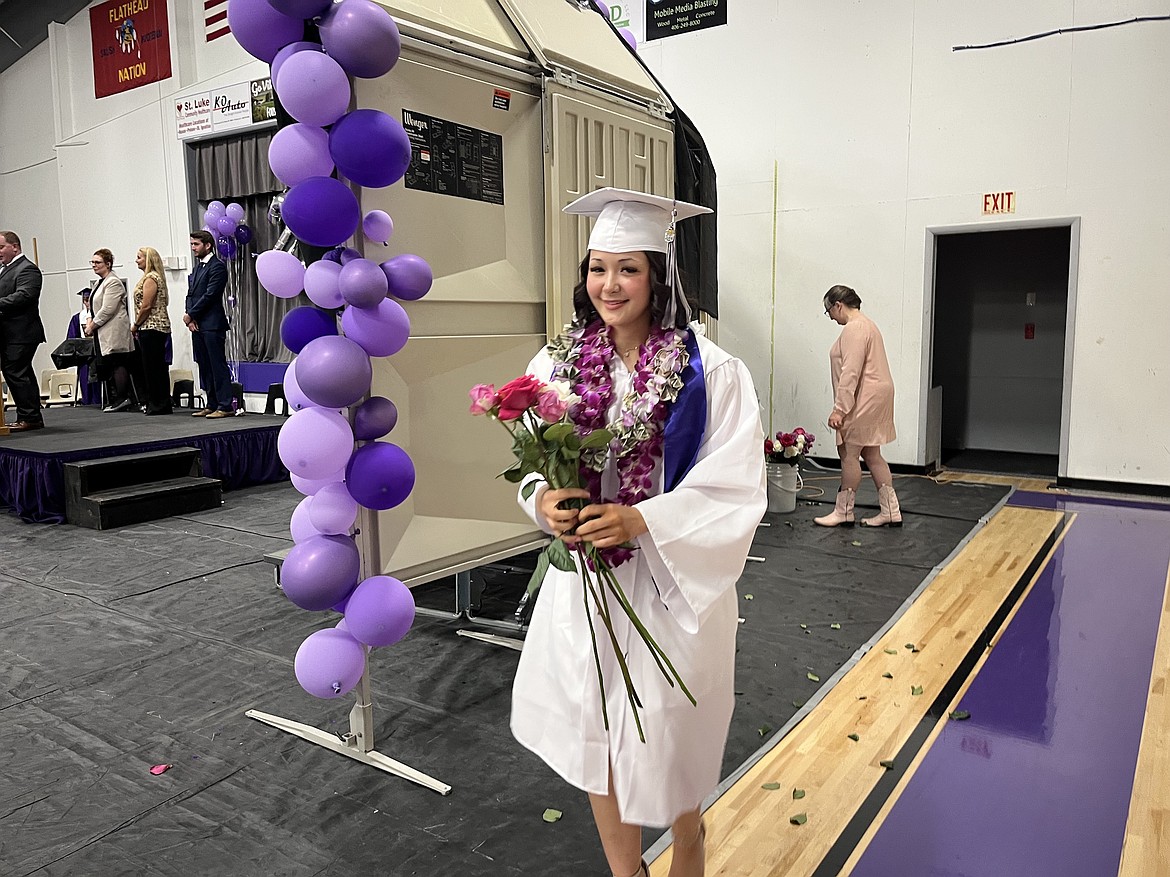 Charlo graduate Emma Shaw heads off to give flowers to her family after receiving her diploma Sunday. (Kristi Niemeyer/Leader)