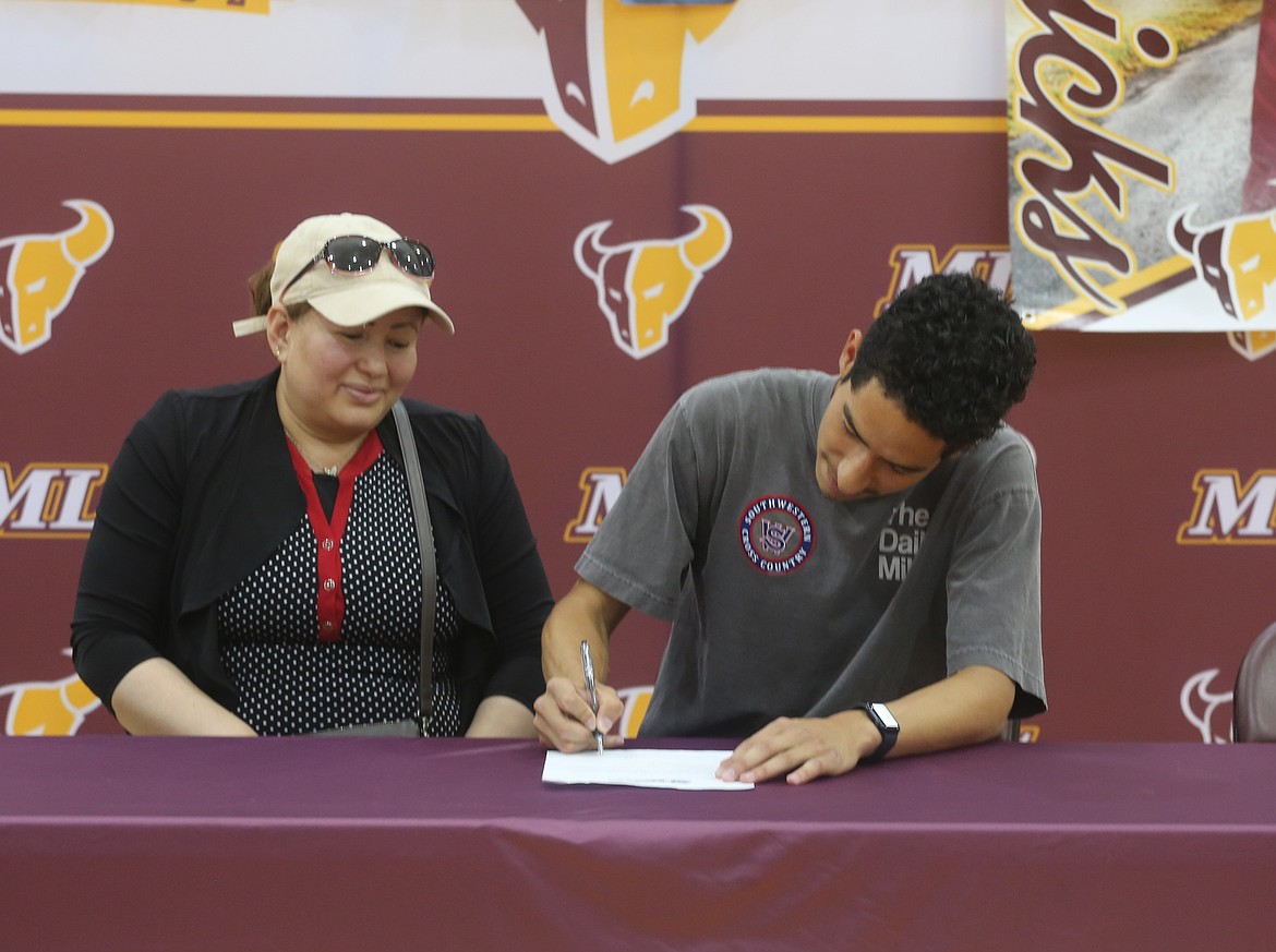 Mavericks Jaciel Valdez signs his letter of intent at Southwest Oregon Community College. Valdez said he is the first in his family to graduate from high school.