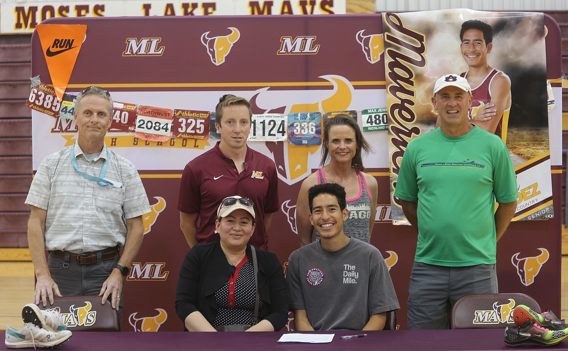 The Mavericks' Jaciel Valdez smiles for a photo surrounded by his coaching staff. Head coach Larry Dagnon, far right, praised Valdez for his high character and work ethic.