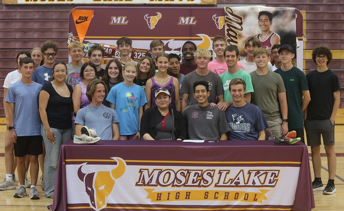 Mavericks Jaciel Valdez smiles for a photo surrounded by teammates, friends, and his mother. Many of his teammates spoke openly about his work ethic and dedication to the cross-country team.
