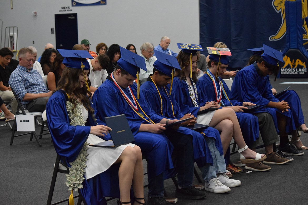 The graduates at Moses Lake Christian Academy bow their heads in prayer at their ceremony May 31. A total of seven students graduated.