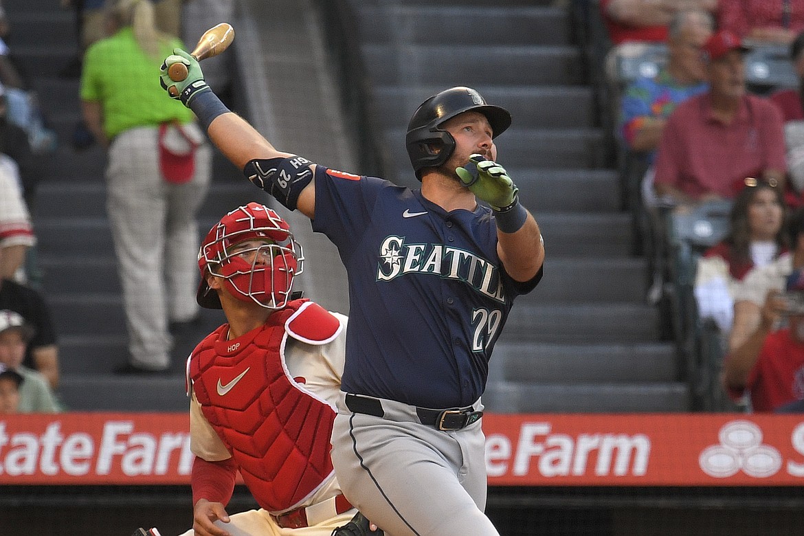 Seattle Mariners' Cal Raleigh, right, hits a two-run home run as Los Angeles Angels catcher Logan O'Hoppe watches during the first inning of a baseball game Saturday, June 7, 2025, in Anaheim, Calif.