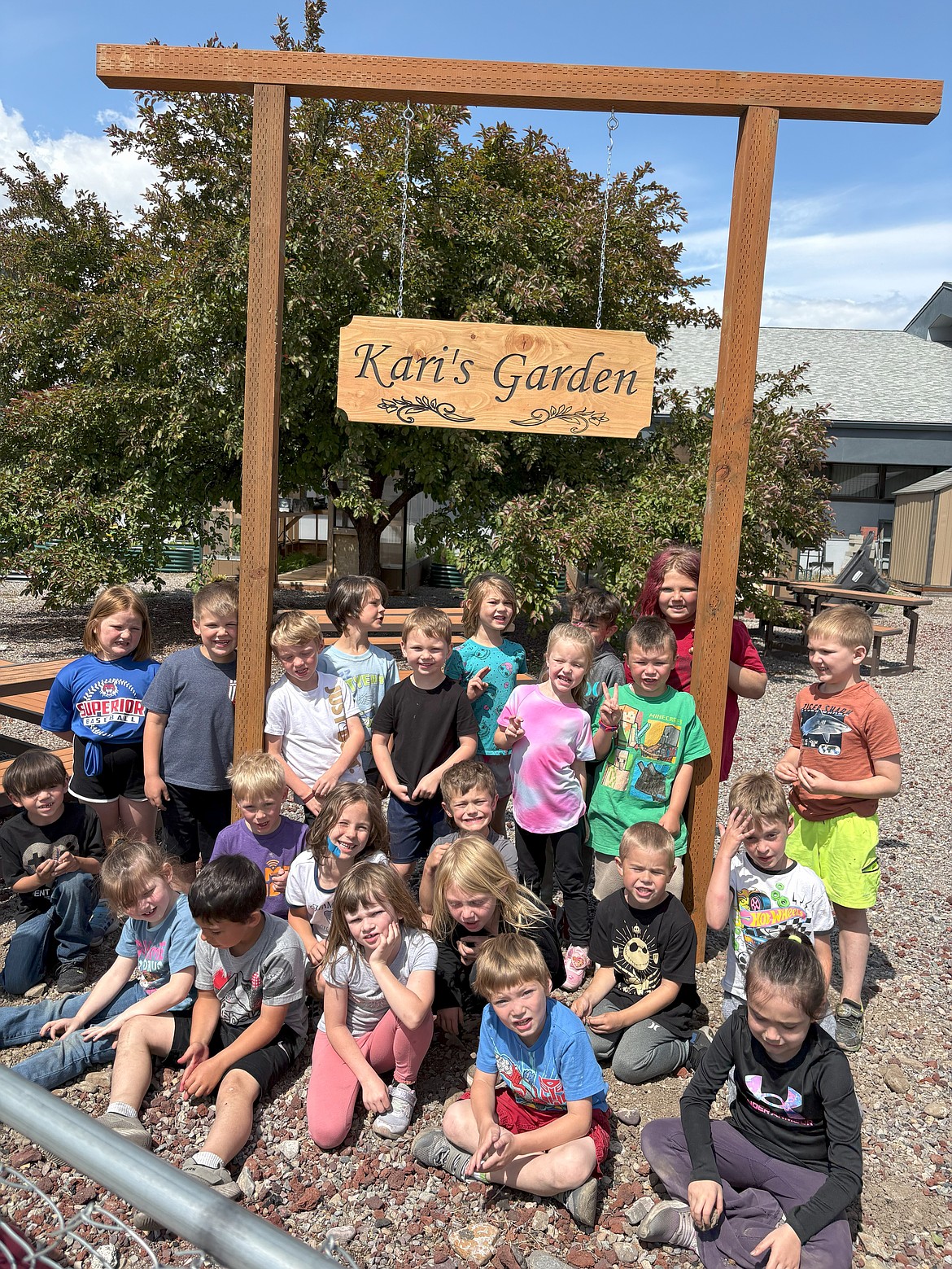 Superior Elementary School kindergartens stand with a new sign dedicating a garden in Kari Labbe's memory. Labbe was a kindergarten teacher for decades. (Photo provided)
