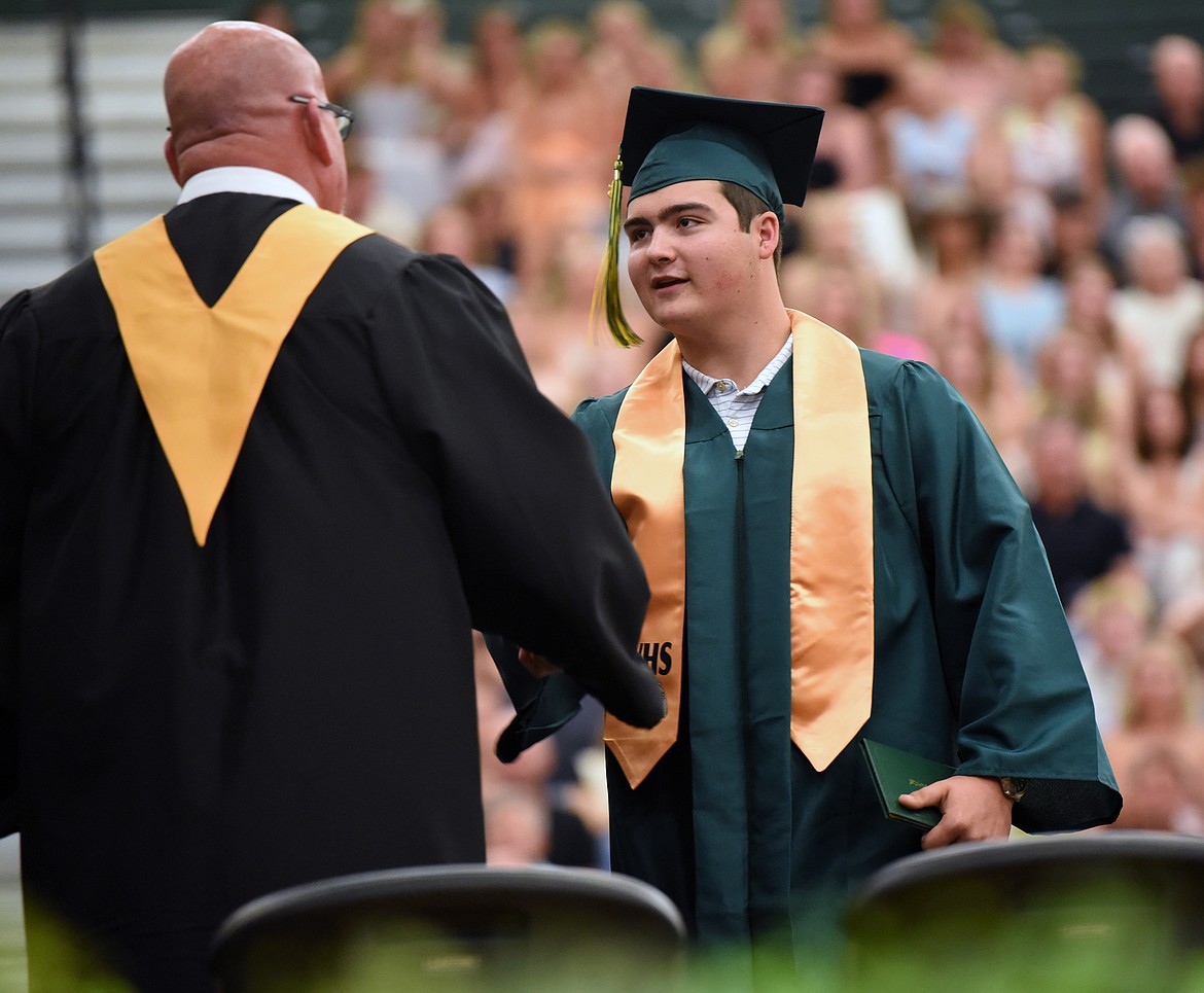 A graduate shares a handshake with Principal Drown. (Kelsey Evans/Whitefish Pilot)