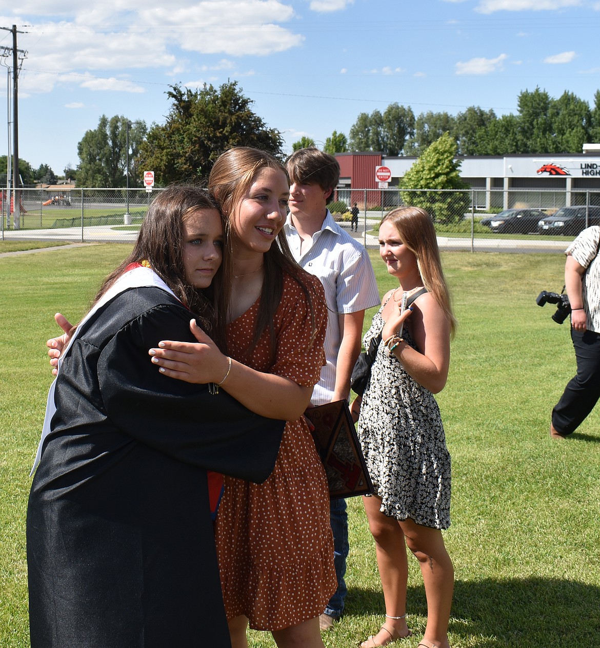 LRHS graduate Alyssa Williams, left, and junior Zoe Galbreath share a hug after commencement Saturday.