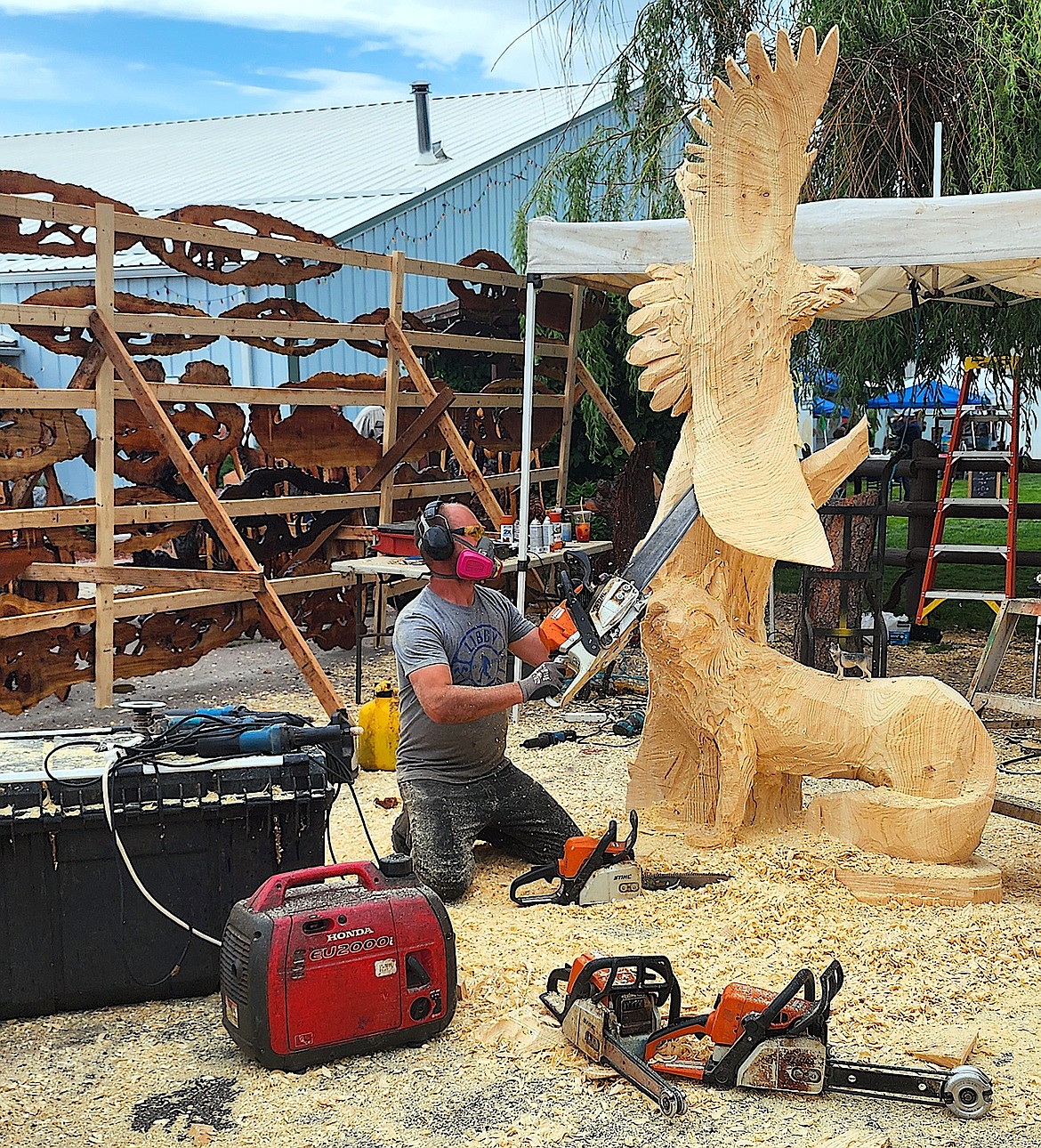 Chain saw artist Alex Precob has his saws and tools ready to go as he works on his contest piece. (Berl Tiskus/Leader)