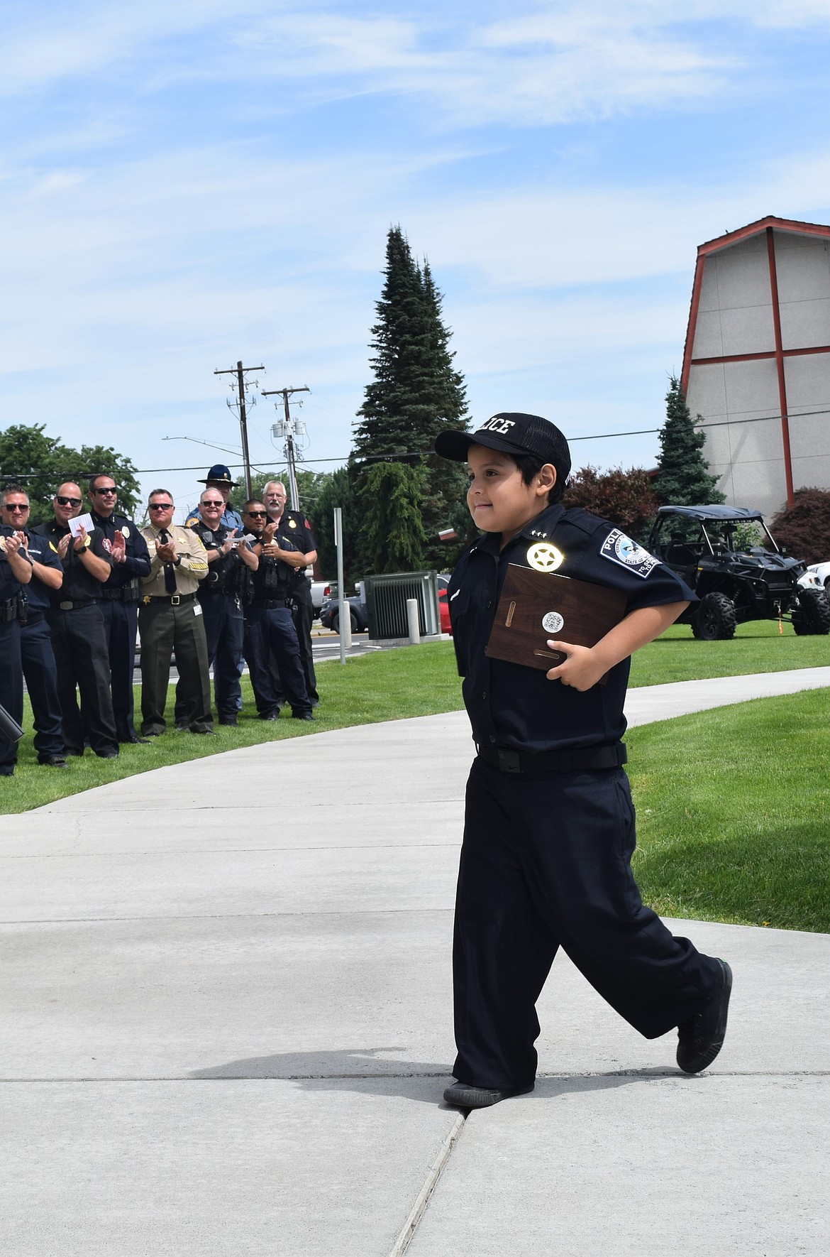 Quincy Police Chief Adam Torres walks up to receive his certificate during Chief for a Day June 12.