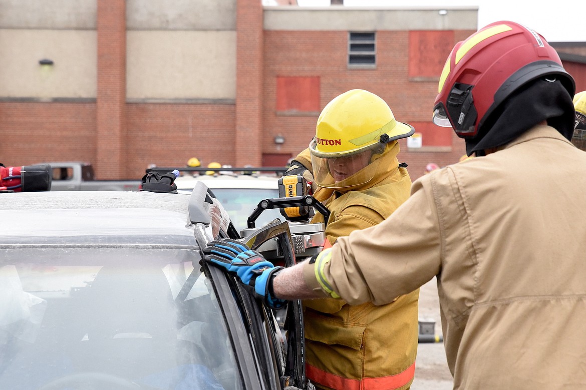 A firefighter uses an extrication tool to remove a door from a car during a training exercise at the 70th Annual Montana Volunteer Firefighters Convention, hosted in Libby. (Scott Shindledecker/The Western News)