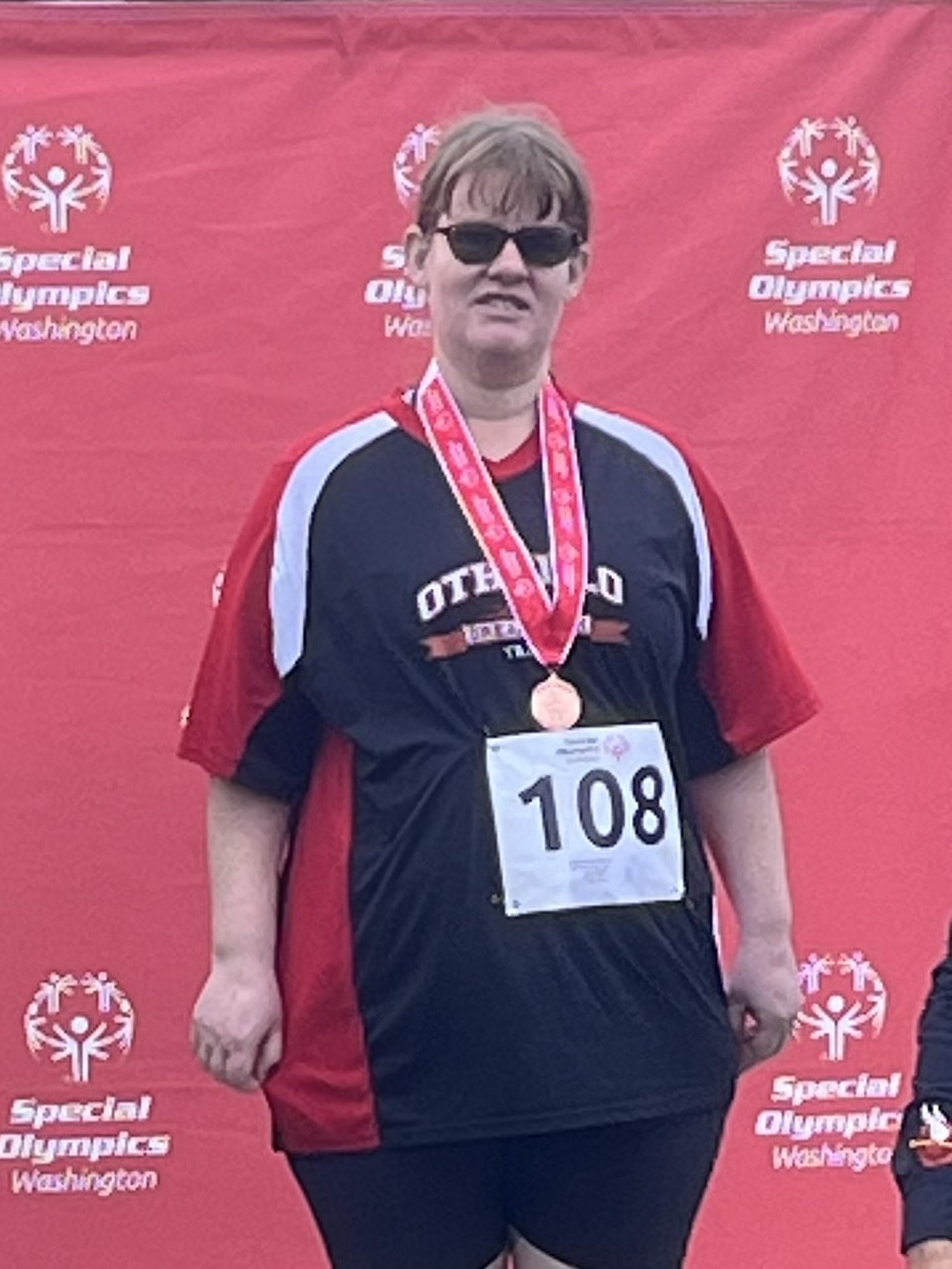 Megan Lembcke with the Dream team stands at the podium after earning a bronze in javelin. She also earned a silver medal in the 50m run and another bronze in the 200m run.
