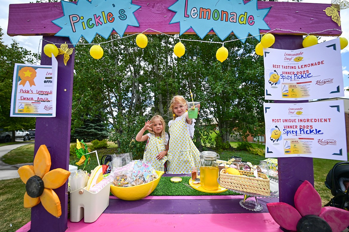 Mabel and Emma Anvik hold up a cup of their Spicy Pickle Lemonade at their Pickle's Lemonade stand for Lemonade Day on Saturday, June 28. (Casey Kreider/Daily Inter Lake)