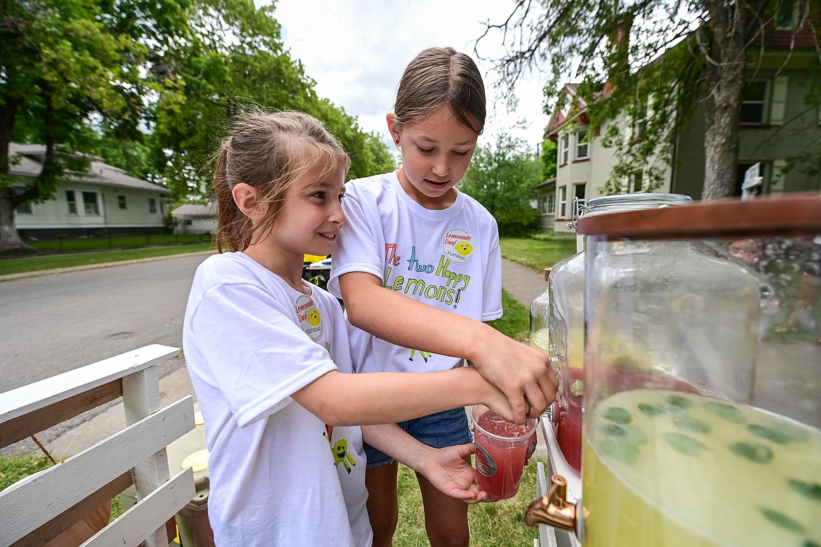 Lucy and Parker Waldenberg pour a cup of cherry basil lemonade at their Two Happy Lemons stand for Lemonade Day on Saturday, June 28. (Casey Kreider/Daily Inter Lake)