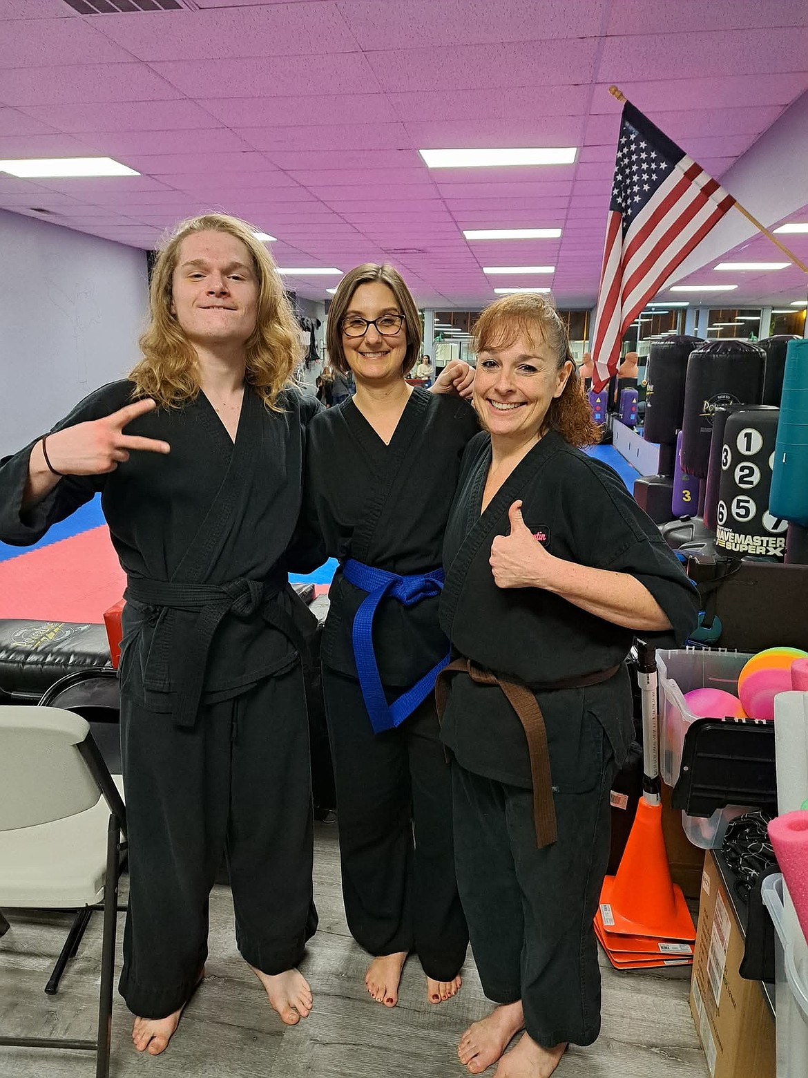 Jessie Young with Jacob and Brandi Guertin after she earned her blue belt at Freewind Martial Arts. Young said the family atmosphere is what drew her to join the studio as a student.
