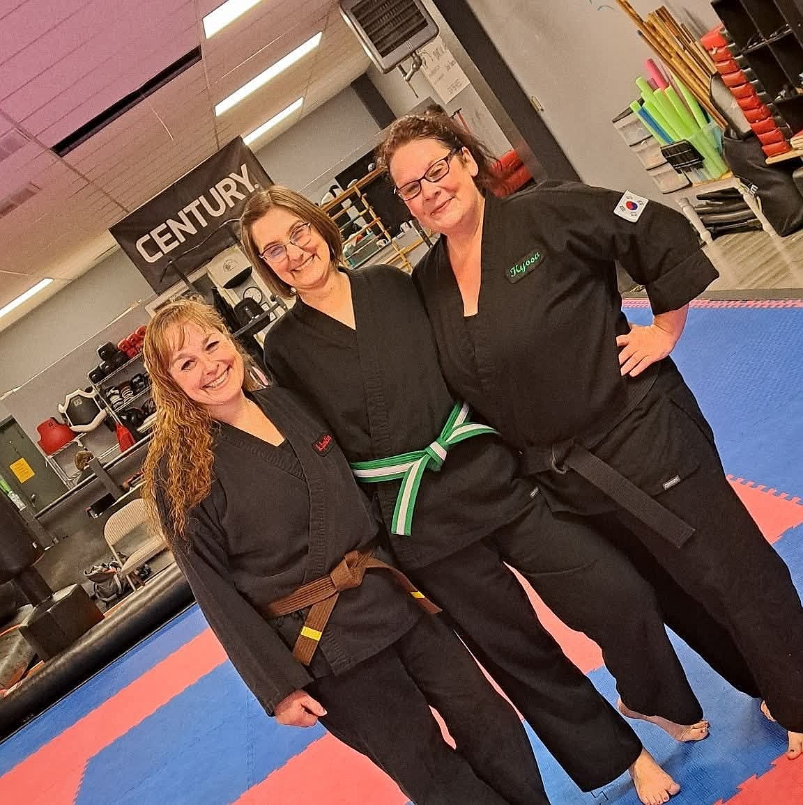 Jessie Young with Brandi Guertin and Jamie Casteel after she earned her green belt. Young said working with the bo staff is one of her favorite elements of the martial arts.