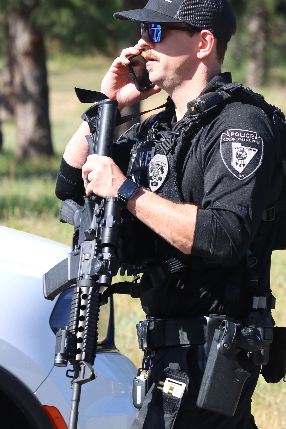 A Coeur d'Alene police officer responds to Cherry Hill Park near Canfield Mountain on Sunday after two firefighters were shot and killed.
