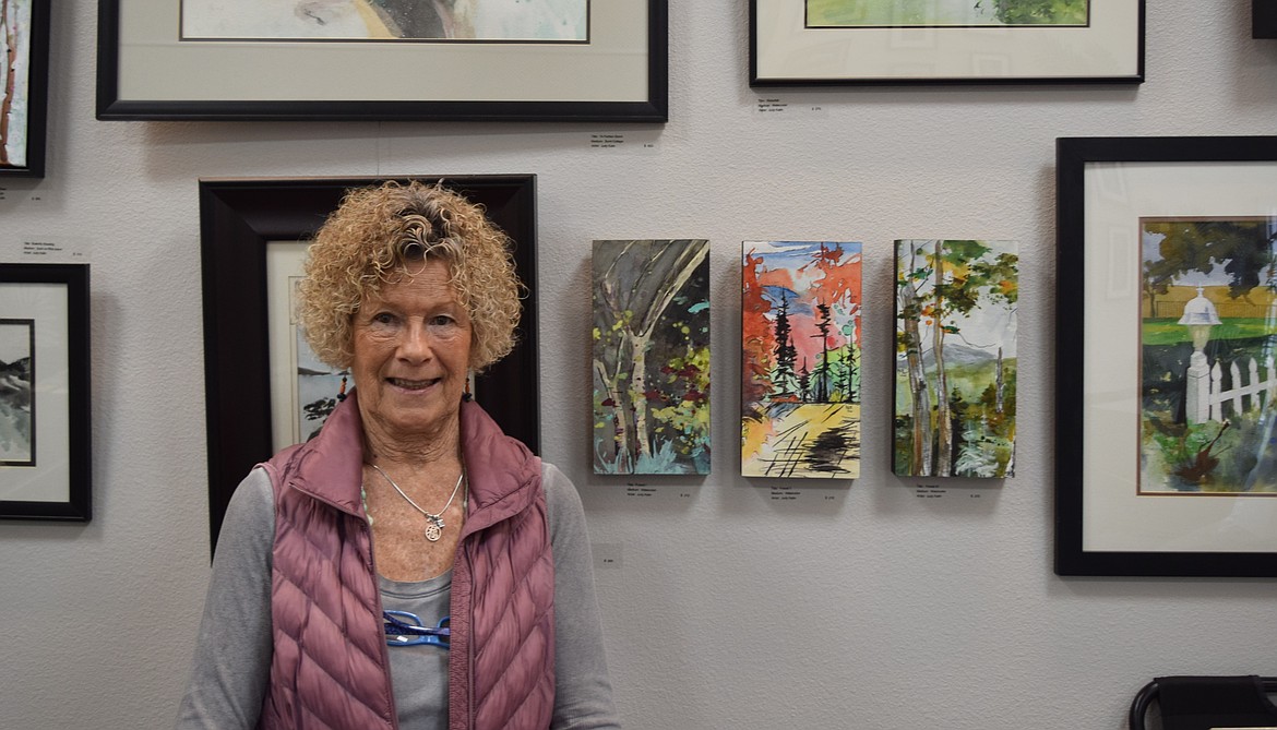 Judy Kalin, co-owner of the Up Town Art Gallery, stands near her painting.