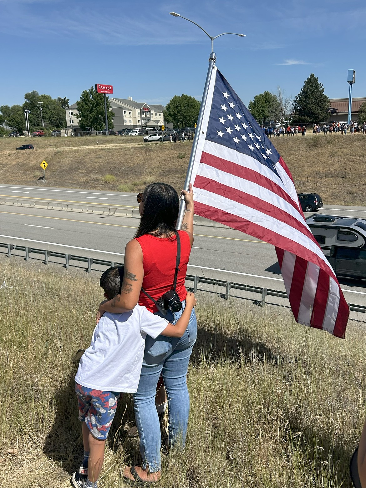 A woman and her son hold a flag along I-90 on Tuesday.