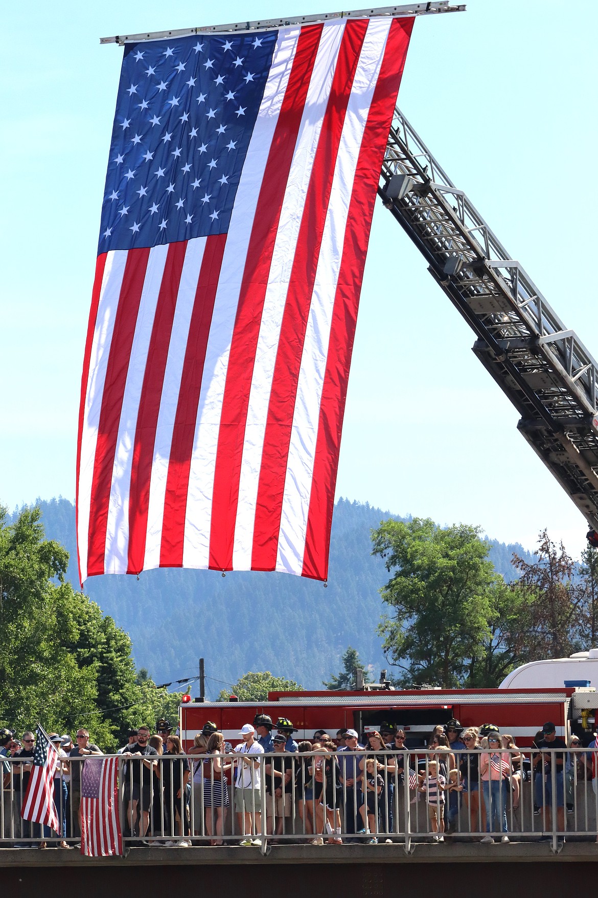 A giant flag hangs from the Fourth Street bridge as the crowd awaits the procession.
