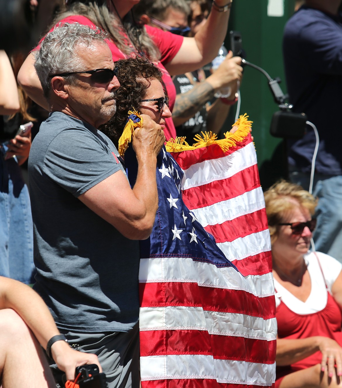People hold a flag as the procession passes by in downtown Coeur d'Alene.