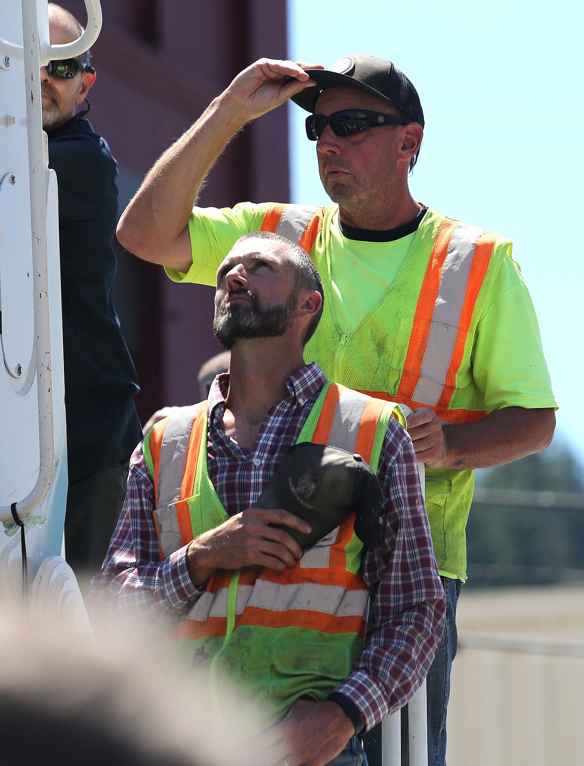 Two men pay their respects as the procession passes by.