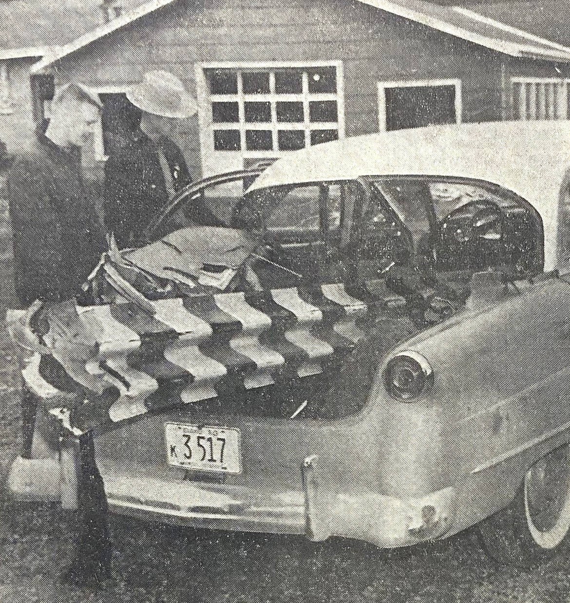 Patrolman P.J. Monaghan, right, and resident Shelton Forest surveyed Ralph Lawrence’s destroyed vehicle in 1960.