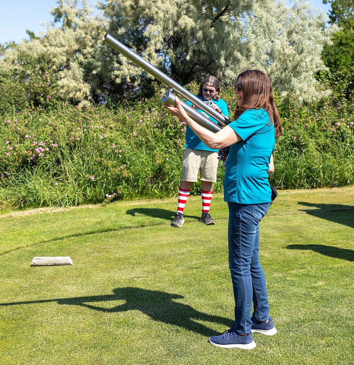 Judy Henninger holds a cannon at the AG World Golf Classic. At one of the holes, golfers could shoot their golf balls with a cannon.