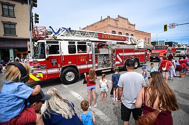 Attendees watch as a series of emergency vehicles, including Evergreen Fire Rescue's Ladder 841, roll down Main Street at the Kalispell 4th of July Parade on Friday, July 4. (Casey Kreider/Daily Inter Lake)