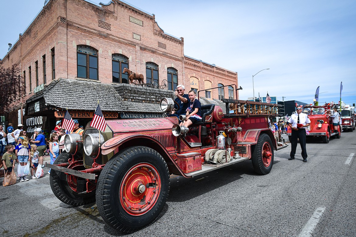 A line of old fire trucks make their way down Main Street at the Kalispell 4th of July Parade on Friday, July 4. (Casey Kreider/Daily Inter Lake)